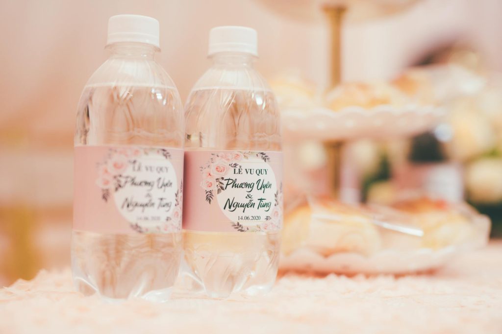 Close-up of personalized wedding water bottles with floral labels.