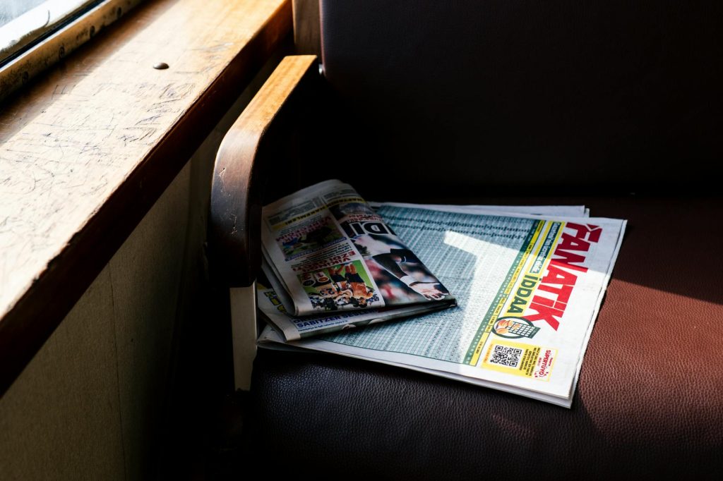 Newspapers lying on a ferry seat in İstanbul, Türkiye, capturing daily life and transport.