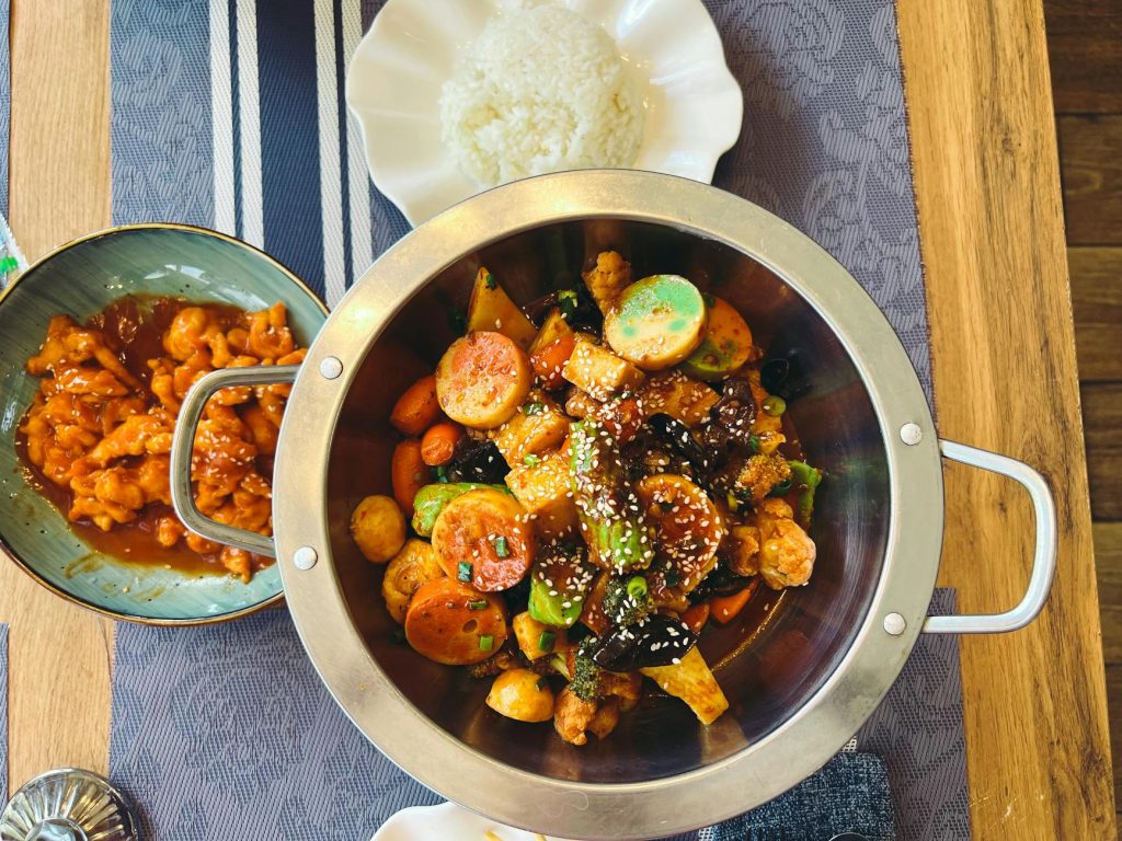 A vibrant spread of Asian cuisine featuring stir-fried vegetables, rice, and chicken in Astana, Kazakhstan.
