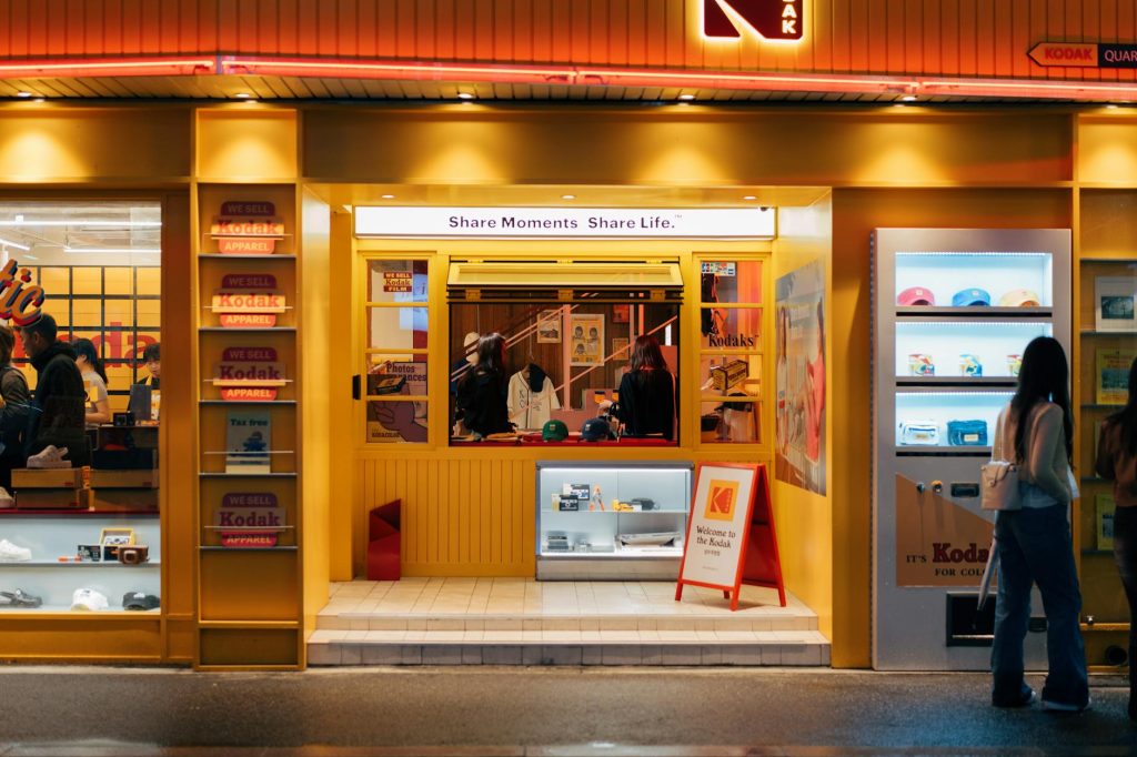 Vibrant Kodak store entrance at night in South Korea, showcasing retro and modern photography items.