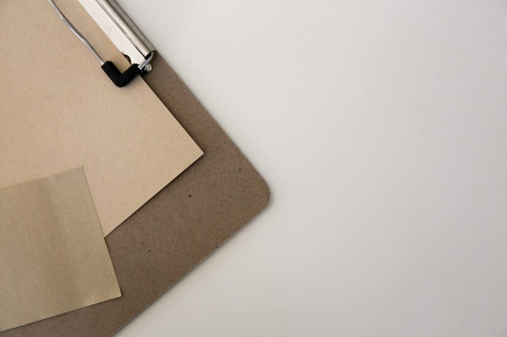 Top view of a clipboard with sheets of cardboard on a white background.