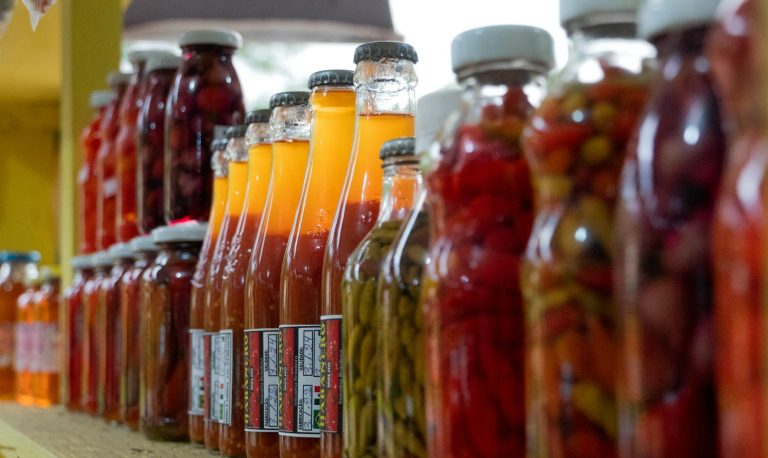 Vibrant assortment of pickled and preserved vegetables in glass jars on display in Morretes, Brazil.