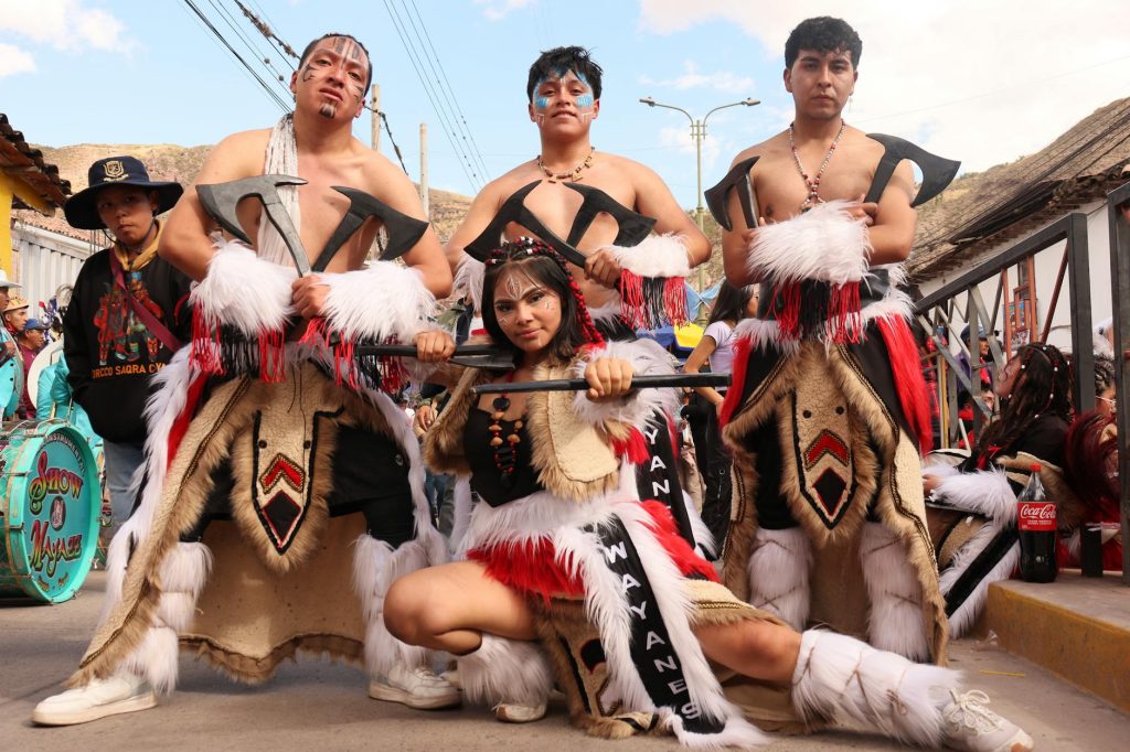 Group in traditional festival costumes with axes and face paint. Vibrant display of cultural heritage.