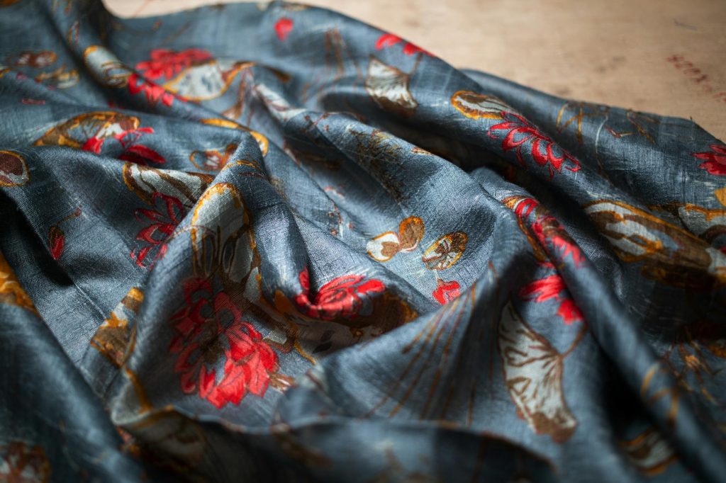 Close-up of elegant floral patterned fabric with rich colors, perfect for fashion and interior designs.