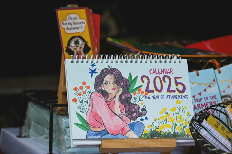 Colorful illustrated 2025 calendar featuring floral design and female portrait.
