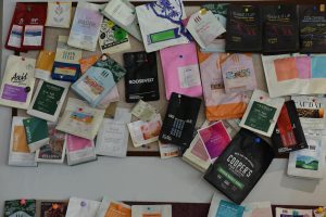 A vibrant collection of diverse coffee packaging pinned on a bulletin board, showcasing various brands.