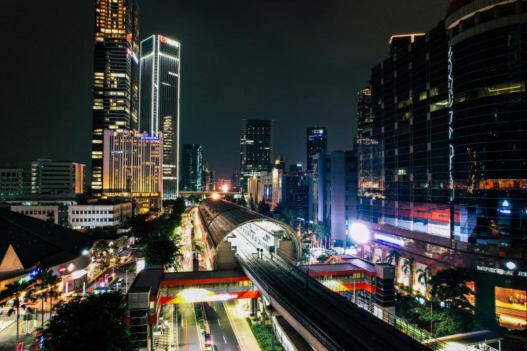 Illuminated skyline and train tracks in South Jakarta's Kuningan area at night.