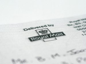 Macro shot of a Royal Mail stamp on a document highlighting postal delivery.