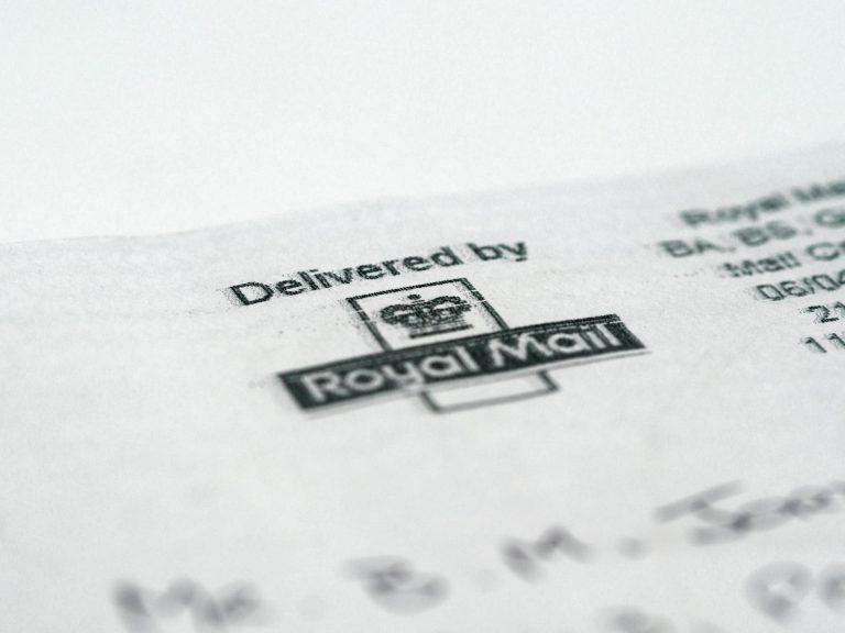 Macro shot of a Royal Mail stamp on a document highlighting postal delivery.