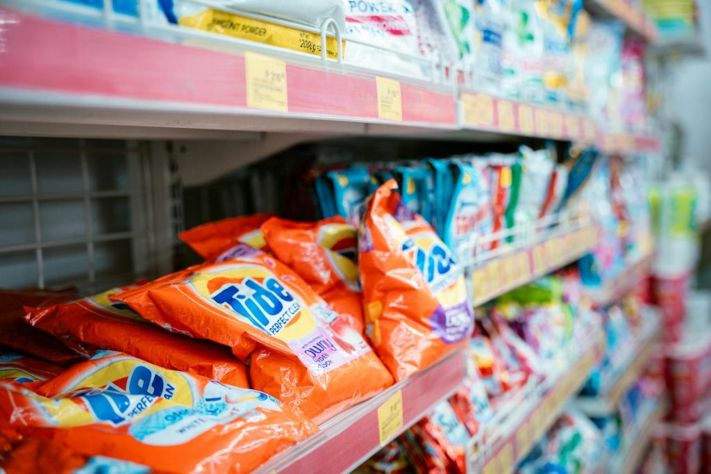 Vibrant selection of laundry detergents on a supermarket shelf, showcasing brands and variety.