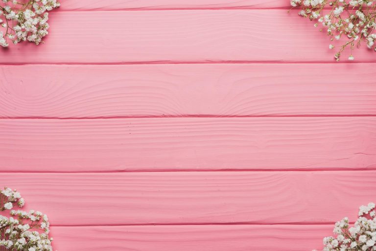 Aesthetic pink wooden background with white baby's breath flowers, ideal for weddings and events.