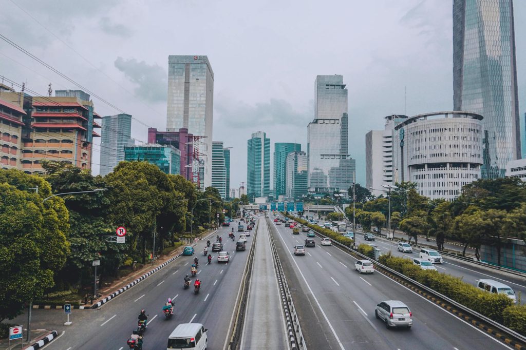 Vibrant Jakarta cityscape showcasing tall skyscrapers and a busy highway with traffic.