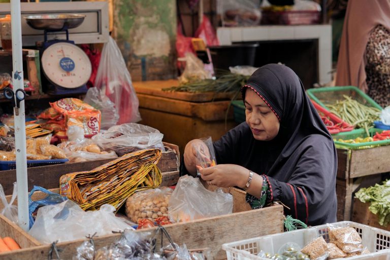 Indonesian market scene with a woman vendor organizing produce. Vibrant and authentic market atmosphere.