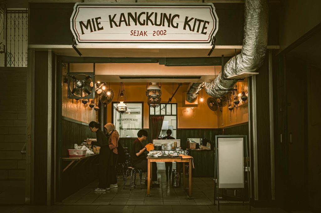 Interior of a traditional Indonesian food stall with people enjoying their meal in South Jakarta.